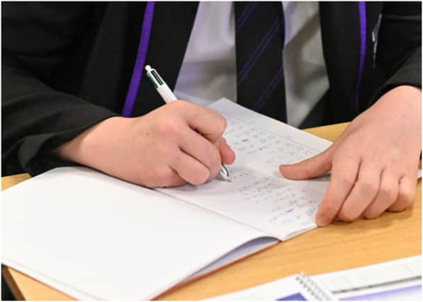 Year 11 students, wearing face coverings, take part in a GCSE maths class at Park Lane Academy in Halifax, northwest England on March 8, 2021 as schools reopen following the easing of lockdown restrictions. (Photo by Oli SCARFF / AFP) (Photo by OLI SCARFF/AFP via Getty Images)