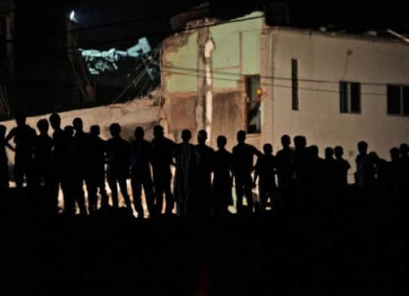 Bangladeshi men watch rescue operations at the site of a building that collapsed. Picture: AP