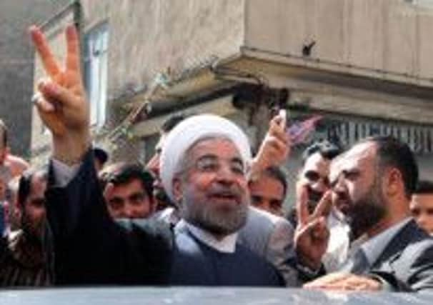 Hassan Rowhani flashes the sign of victory as he leaves a polling station after voting. Picture: Getty