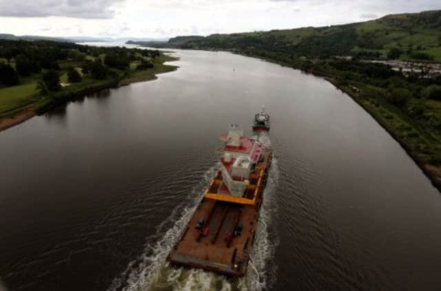 The Aft Island of HMS Queen Elizabeth leaves via barge down the River Clyde heading for Rosyth. Picture: PA