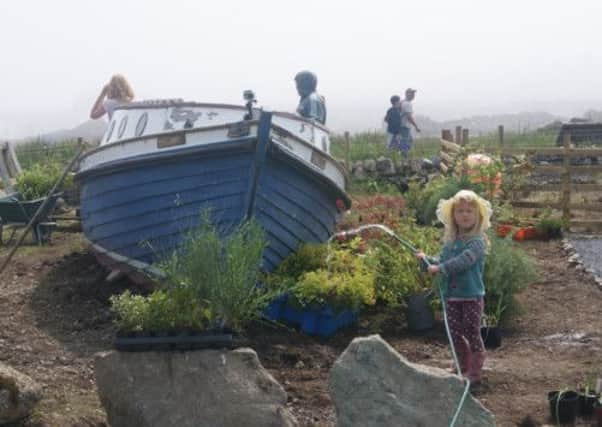 Young Helen Piper helps out with a spot of watering. Picture: Contributed