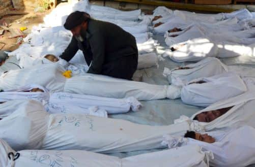 A man holds a dead child's body. Picture: Reuters