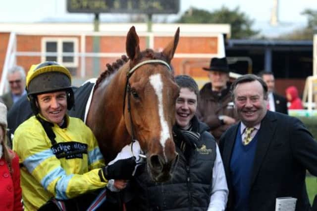 Hennessy winner Triolo DAlene is flanked by jockey Barry Geraghty and Nicky Henderson. Picture: PA