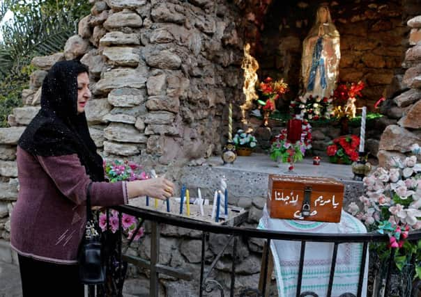 An Iraqi Christian woman lights candles before a Christmas mass in Basra. Picture: AP