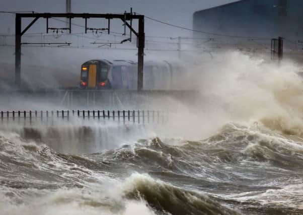 A ScotRail train passes through stormy Saltcoats. Picture: PA