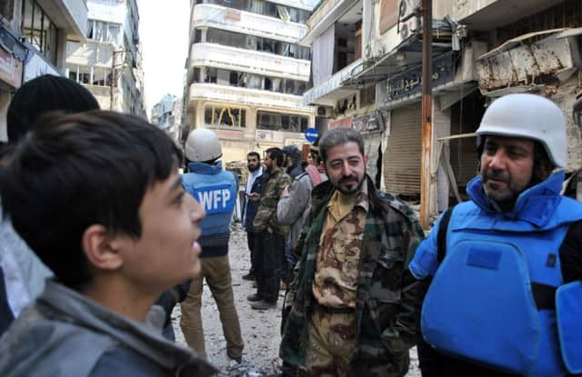 Aid convoy workers with locals in Homs. Picture: AFP/Getty