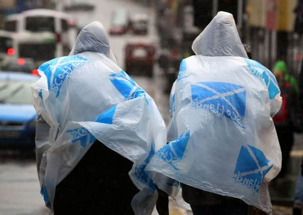 Tourists take cover from the rain and wind in Edinburgh. Picture: PA