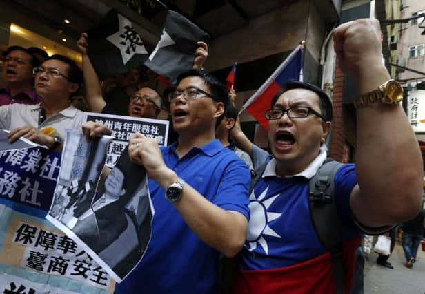 Pro-Taiwan students tear a portrait of Vietnamese President Truong Tan Sang. Picture: Reuters