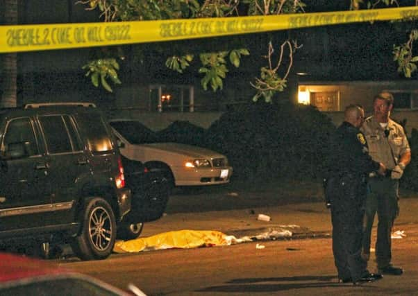 Police stand near a dead body at the scene of a drive-by shooting in Isla Vista, California. Picture: Reuters