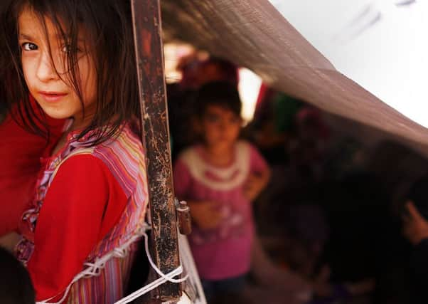 An Iraqi girl and her family wait to get into a temporary displacement camp for Iraqis caught up in the fighting. Picture: Getty Images