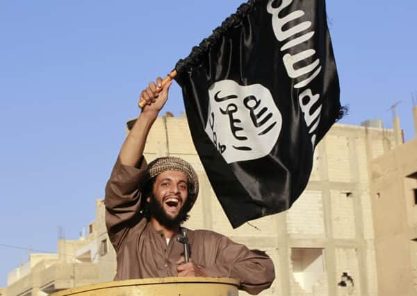 A militant Islamist fighter waves a flag as he takes part in a military parade in Syria's northern Raqqa province. Picture: Reuters