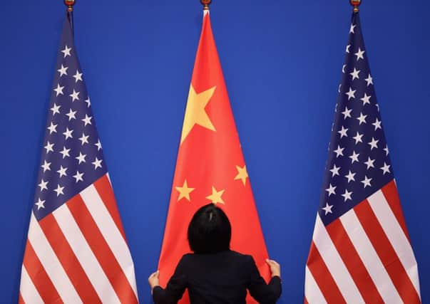 An official adjusts the Chinese flag before the opening of the summit in Beijing. Picture: Getty