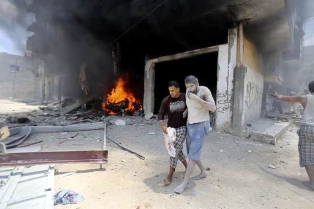 A Palestinian helps a wounded man reach help after an airstrike in Rafah, southern Gaza yesterday. Picture: Reuters