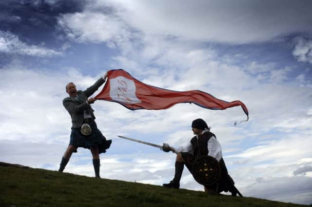 Dr Gordon Prestoungrange, left, and Adam Watters raise the 1745 Standard on the Battle of Prestonpans. Picture: Colin Hattersley