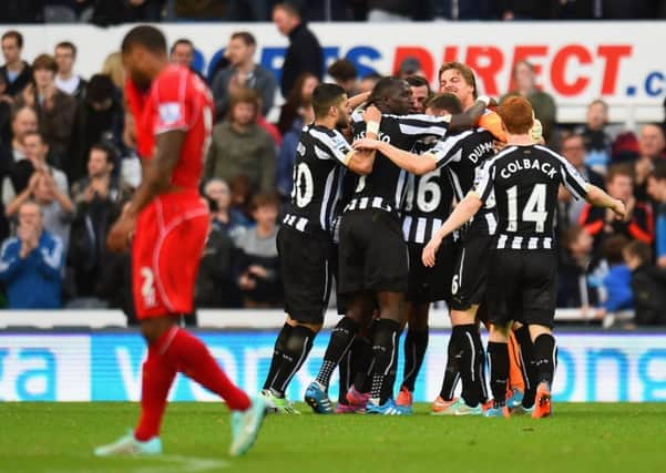 Glen Johnson walks away as the Newcastle players celebrate Ayoze Perezs goal. Picture: Getty