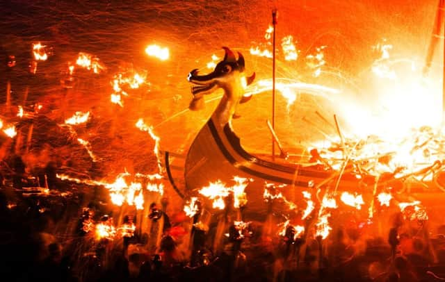 Guizers throw flaming torches in to the 'Viking longship' during the Up Helly Aa festival, in Lerwick. Picture: PA