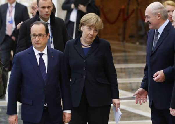 Belarus president Alexander Lukashenko, right, with Francois Hollande and Angela Merkel. Picture: AP