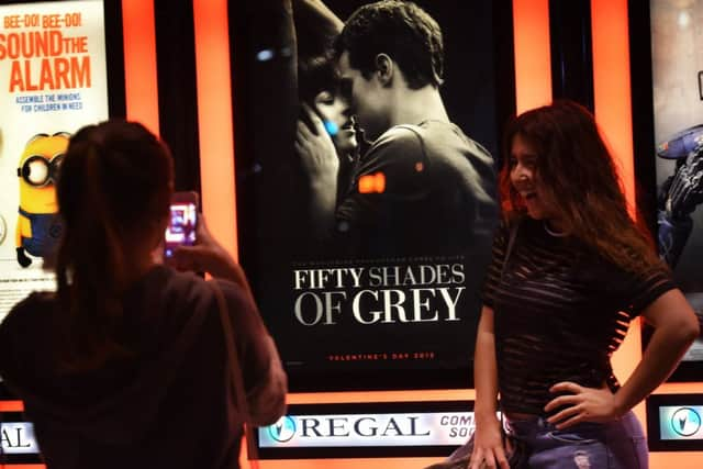 Women pose for photos in front of a poster advertising the film. Picture: Getty