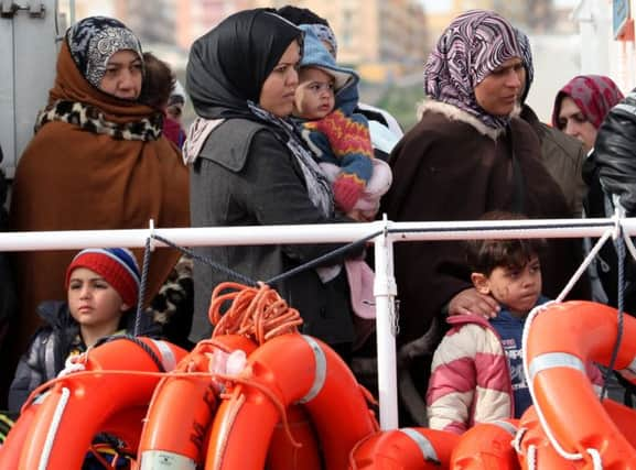 Rescued migrants wait to disembark from an Italian coastguard vessel on Sicily. Picture: AP