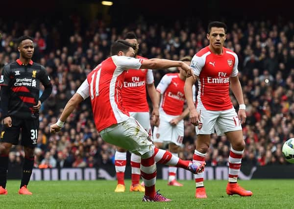 Arsenals German midfielder Mesut Ozil fires in a free-kick to score their second goal against Liverpool. Picture: Getty Images