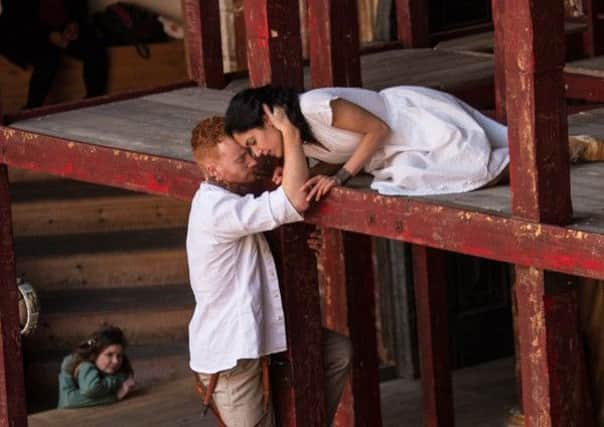 The cast use a simple wooden booth stage of the kind touring players of Shakespeares day might have used