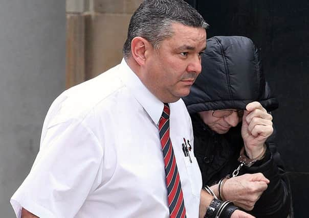 Alexander McAuslan (right) attempts to shield his face outside Dumbarton Sheriff Court. Picture: Stewart Robertson