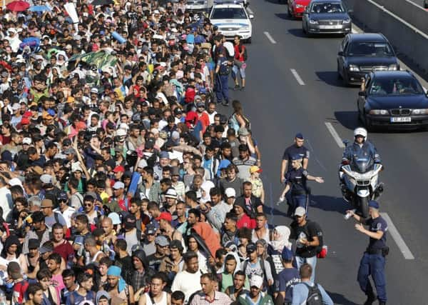 Refugees who left Keleti station in Budapest, Hungary, yesterday begin their journey on foot to Austria, where they hope to receive a more sympathetic reception. Picture: AP