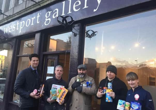 Dundee Night Market organiser Richard Cook (centre), along with friends of the community, holds donations for Dundee Foodbank with Adam Hutcheson of Westport Property (far left) and Tesco employee Tracey (far right). Photo: Richard Cook