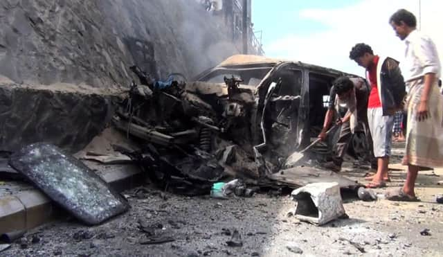 Passers-by examine the wreckage of Governor Gaafar Mohamed Saad's vehicle. Picture: AFP/Getty