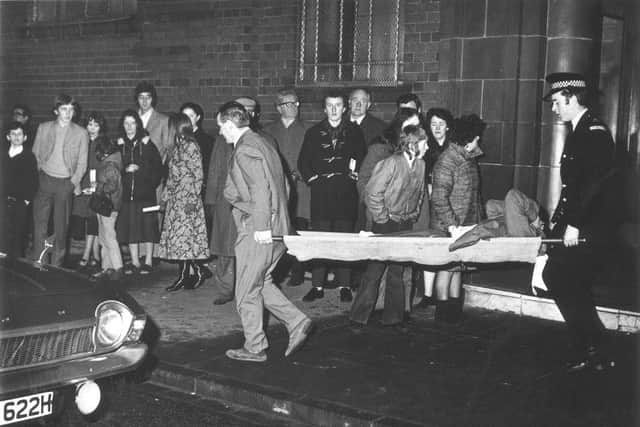 Celtic coach Neil Mochan helps carry an injured fan following the Ibrox stadium disaster in 1971. Picture: Allan Milligan