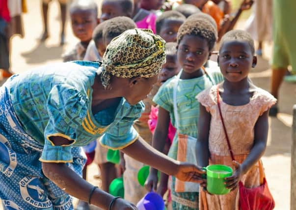 A volunteer cook from Scottish charity Marys Meals, which is to receive Â£5 million funding from the UK government, serves food to a girl in Malawi. Picture: PA