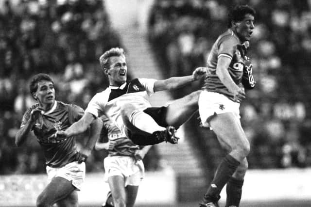 Rangers' 
Ted McMinn feel the full force of a John Brown challenge as Ally McCoist looks on during a Skol Cup tie with Dundee in 1986. Picture: SNS