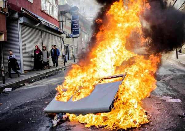 People walk past a fire during a May Day rally in Okmeydani. Picture: AFP/Getty Images