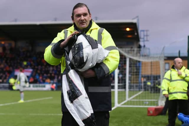 A steward confiscates a banner. Picture: SNS