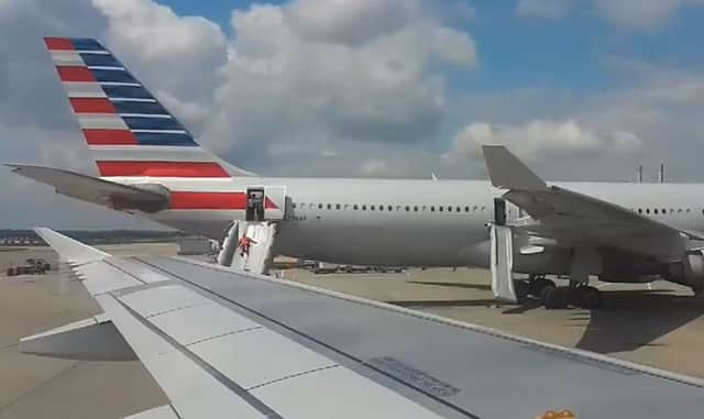 Passengers escaping from an American Airlines plane down an emergency slide at Heathrow Airport. Picture: @rosshiscock/PA