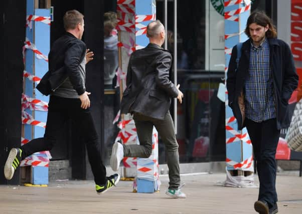 Ewan McGregor and Ewan Bremner sprint down Princes Street during Trainspotting 2 filming. Picture: Getty Images