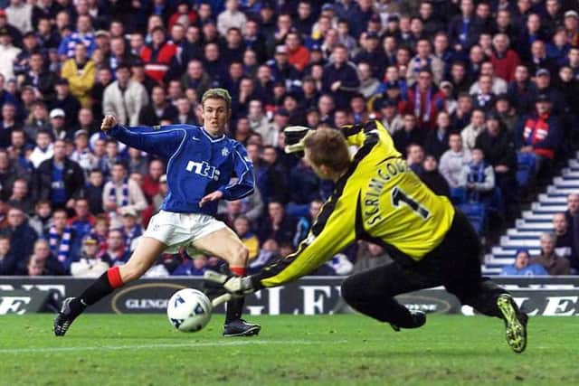 Kenny Miller slots the ball past goalkeeper Derek Scrimgour for the fourth of his five goals in a 7-1 victory over St Mirren. Picture: SNS