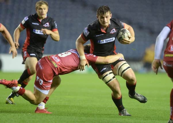 Edinburghs Magnus Bradbury evades the clutches of Scarlets Aled Davies. Pic: SNS/SRU