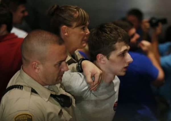 Police lead Michael Sandford away from the Treasure Island hotel and casion in Las Vegas. Picture: AP/John Locher