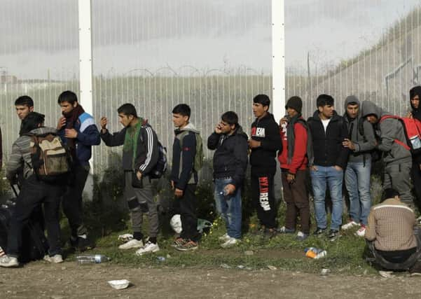 Migrants queue for busses to leave the makeshift migrant camp known as "the jungle" near Calais. Picture: AP/Matt Dunham