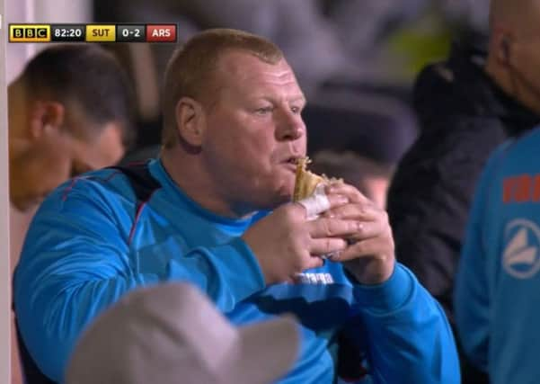 Sutton's reserve goalkeeper Wayne Shaw eating a pie on the touchline. Picture: BBC/PA