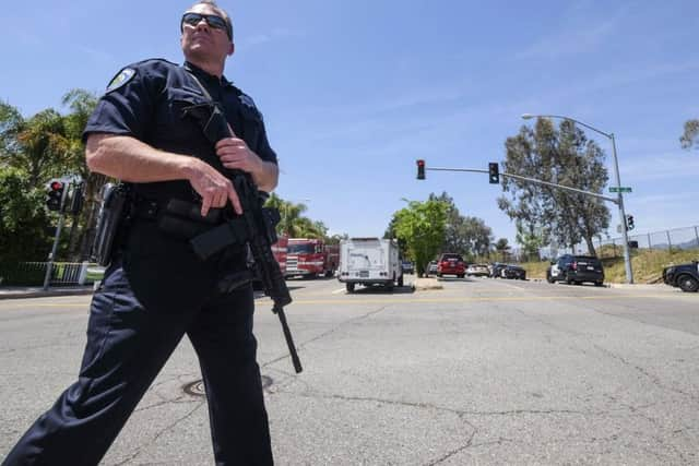 A police office stands guard outside North Park School after a fatal shooting (AP Photo/Ringo H.W. Chiu)