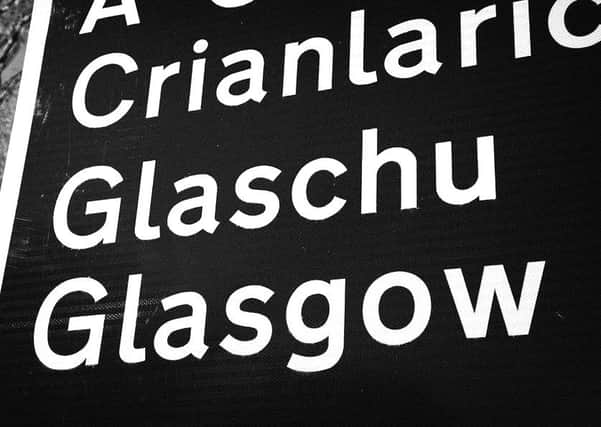 A bilingual sign pointing the way to Glasgow
