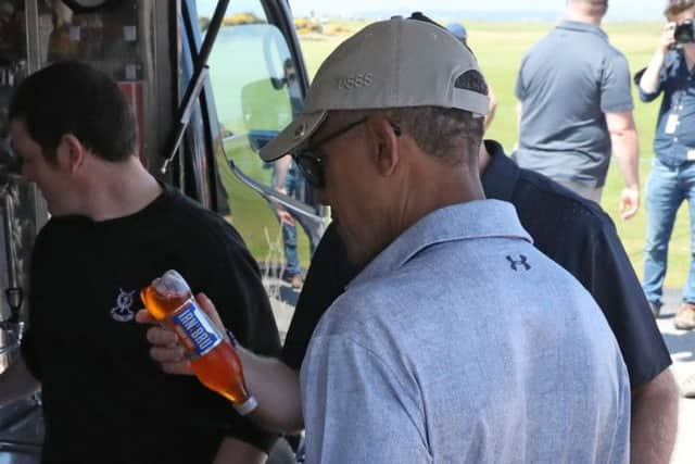 Sir Tom Hunter (partially obscured) shows a bottle of Irn-Bru to former US president Barack Obama. Pic: Andrew Milligan/PA Wire