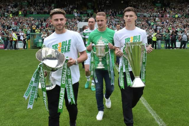 Celtic's Patrick Roberts, Leigh Griffiths and Kieran Tierney with the three domestic trophies. Picture: SNS