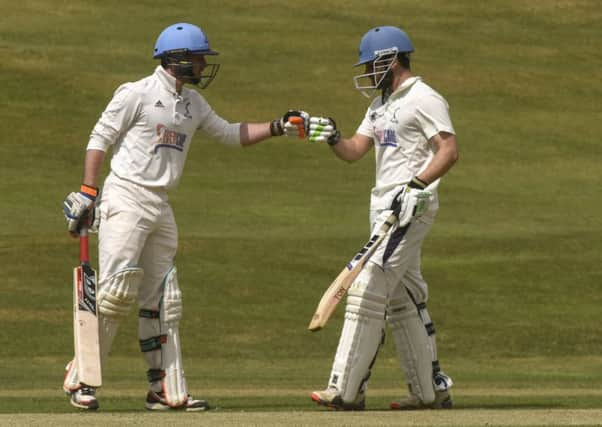 Carlton batsman Ali Shah, right, celebrates his 50 with Fraser Boyd as the champions enjoyed a 116-run victory over Heriot's. Picture: Andrew O'Brien