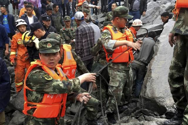 Emergency personnel work at the site of a massive landslide in Maoxian County in southwestern China's Sichuan Province. Picture: AP