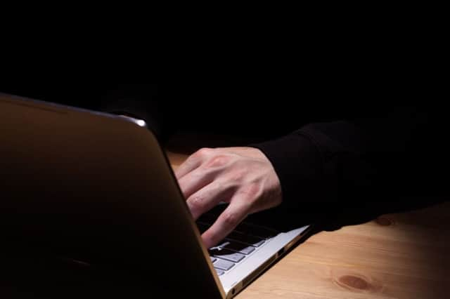 Anonymous person with notebook in the dark