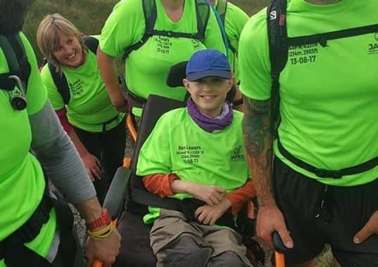 Alex Medley was carried to the top of Ben Lomond by volunteers. Picture: SWNS