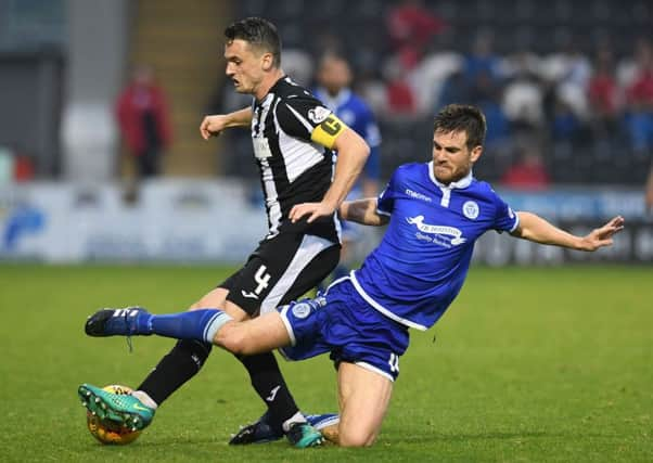 Stephen McGinn of St Mirren resists a strong challenge by Queen of the Souths Kyle Jacobs. Picture: SNS.